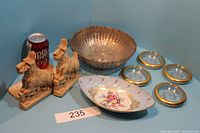 Wide shot showing all items in lot: silver basket, Scotty dog bookends, four coasters, and Limoges dish