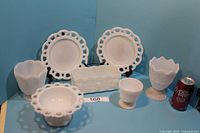 Front angle photo showing all 7 white milk glass items with a soft blue background and soda can for scale.