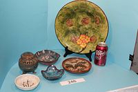 Full view of all items including large green plate, covered container, smaller bowls, and a soda can for scale