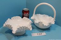 Front view of white milk glass hobnail basket with handle and candle holder beside a Dr Pepper can for size reference