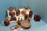 Full view showing assortment of Inuit carvings including animals and birds, wooden pencil holders, a glass ashtray, and carved stone ashtray.