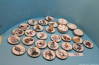 Top-down view of entire collection showing all 40 plates laid out on a blue surface including Norman Rockwell themed plates and floral pattern plates.