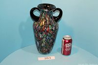 Murano glass vase with double handles next to a soda can for size reference