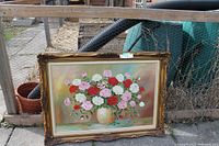 Full view of the framed painting showing colorful flowers in a vase outdoors against a wooden fence.
