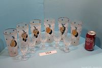 Full set of 6 glasses including 5 tall fruit motif glasses and 1 smaller cut glass goblet beside a soda can for size comparison.