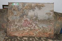 Full view of the tapestry showing the boy and girl in natural surroundings with dogs and a fountain, placed on a floral patterned couch.