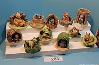 Full set of 11 woodland animal figurines on tiered display showing each piece
