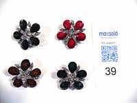 Top view of the 4 vintage floral brooches in black, red, brown, and dark green colored stones with rhinestone accents.