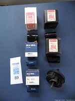 Photo showing six hole saws including Blu-Mol in blue boxes, Simonds in white/red boxes, and one unbranded black hole saw.