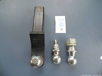 Three 2" ball hitches on a gray surface showing Valley V-5 with square shank and two others with bolt mounts.