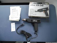 Front view of the Black & Decker 3/8 inch VSR drill with instruction manual, original box, and a numbered tag.