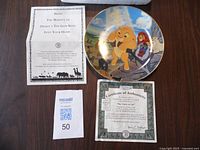 Photo of front of the collectible plate showing colorful Lion King image with Simba and Nala, plus accompanying Certificate of Authenticity and informational sheet.