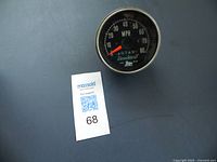 Front view of Brockway antique speedometer showing black dial with white markings and red needle up to 80 MPH.