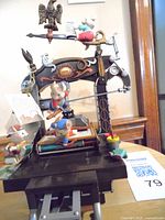 Front view of vintage Enesco multi-action music box showing Santa figurine on top, various animals playing instruments, detailed musical instrument frame, and black piano base.