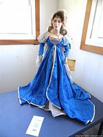 Front view of Franklin Mint Queen Arwen Evenstar doll with blue velvet gown and sheer cape, doll displayed standing.