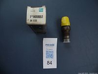 Photo of General Motors 6.2 diesel fuel injector with yellow cap and original box showing part number 14059057 and lot tag number 84.