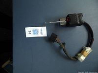 Full view of the TSM commercial truck replacement turn signal assembly showing the handle, wiring harness, and connector plug on a blue surface.