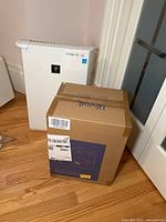 Sharp Plasmacluster air purifier next to Levoit humidifier box on floor