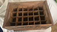 Top-down view of the wooden crate showing internal dividers forming 24 bottle slots.