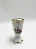 Front view of white porcelain Mazagran vase showing Fragonard style scene and gold accents on rim and base.