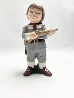 Front view of the vintage ceramic Pilgrim boy figurine, showing facial expression and holding a musket.