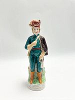 Front view of porcelain soldier figurine standing on green base showing uniform details and facial expression