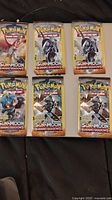 Six unopened 3-card packs of Pokemon Sun & Moon Burning Shadows trading cards, front view showing characters and branding.