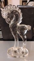 Clear glass crystal pony figurine on oval base with stylized mane and tail.