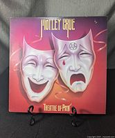 Front cover of the Motley Crue Theatre of Pain vinyl record showing comedy and tragedy masks artwork.