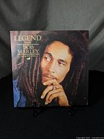 Front cover of the vinyl record showing Bob Marley with hand near face and text 'Legend the best of Bob Marley and The Wailers'.