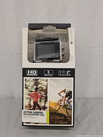 Front of boxed iEessentials action camera showing 5 megapixel resolution, 2 inch screen, and waterproof case.