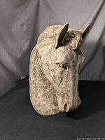 Front view of large decorative horse head sculpture showing detailed face and textured surface.
