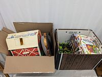 Two boxes filled with assorted toys including Fisher-Price Family Farm playset, Radical Racers cars, Pegaso toy, small cars, and other items