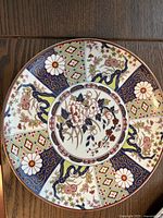 Top view of the Imari ware charger plate showing the detailed floral and crane motifs with geometric pattern segments.