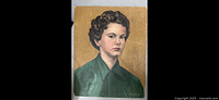 Frontal view of the signed antique portrait art piece showing a young person with curly hair in a green garment with visible creases and wear.