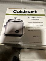 Photo of boxed Cuisinart 4-Cup Rice Cooker & Steamer showing product features on front side.