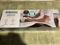 Box of Homedics lumbar pillow showing brand, product type, features, and usage image with a person sitting on a chair using the pillow