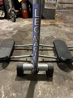 Close-up front view of the Leg Magic foldable exercise machine showing central support and foot pedals.