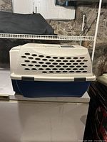 Side view of medium pet carrier showing blue base and beige ventilated top with oval vent holes.
