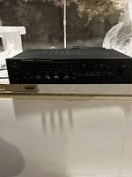 Front view of black Onkyo stereo receiver with FM/AM tuner display and controls.