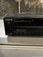 Close-up of the left side front panel of the Sony DVP-NS300 showing power button, disc select buttons, and DVD/CD changer markings.