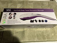 Box showing the VARA Hot/Cold Deep Tissue Percussion Massager, highlighting features including up to 3300 pulses per minute, five interchangeable heads, and hot/cold treatment.