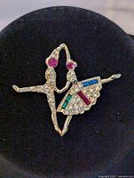 Front view of costume dancers brooch showing gold tone metal and multicolor rhinestones in blue, green, red, and white.