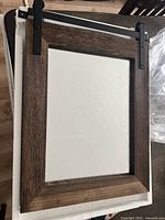Mirror laid flat showing full front with barn wood stained frame and clear glass.