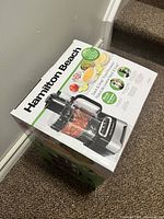 Top angled view of Hamilton Beach food processor box showing brand and product image.