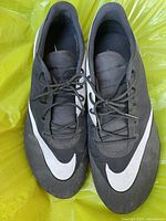 Top view of pair of black Nike golf shoes, showing white swoosh detail and laces.