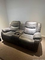 Front and angled view of the brown 2-seater recliner couch with padded armrests and visible seat stitching.