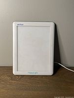 Front view of the white Verilux HappyLight light therapy lamp showing its rectangular light screen and logo.