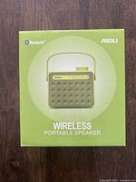 Front face of the AWOLU AY827 wireless portable speaker box showing orange speaker image and Bluetooth logo.