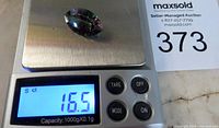 Photo showing the mystic quartz gemstone on a digital scale with display reading 16.5 carats.